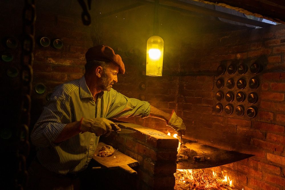 Cuisson de l'asado traditionnel dans l'estancia argentine qui nous accueille en Patagonie