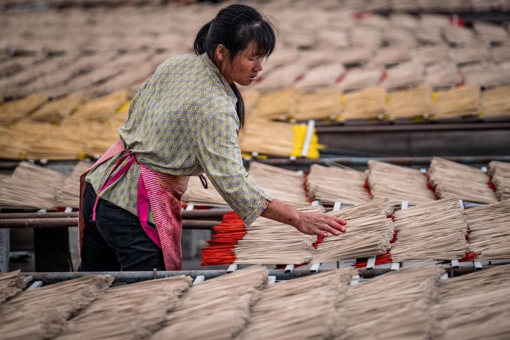 Femme préparant les batonnets d'encens en Chine