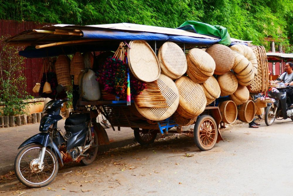 mobylette chargée de paniers dans la campagne cambodgienne