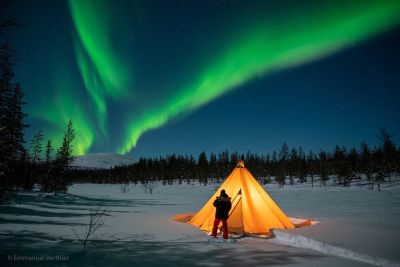 voyageur sous les aurores boreales en laponie
