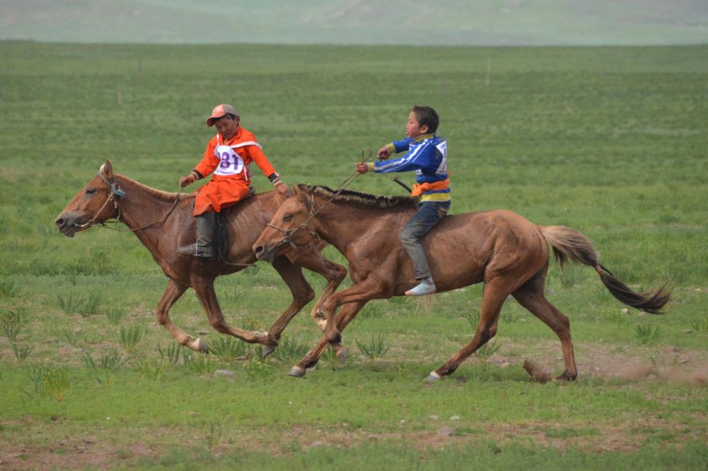 deux chevaux au galop montés par des jeunes garçons